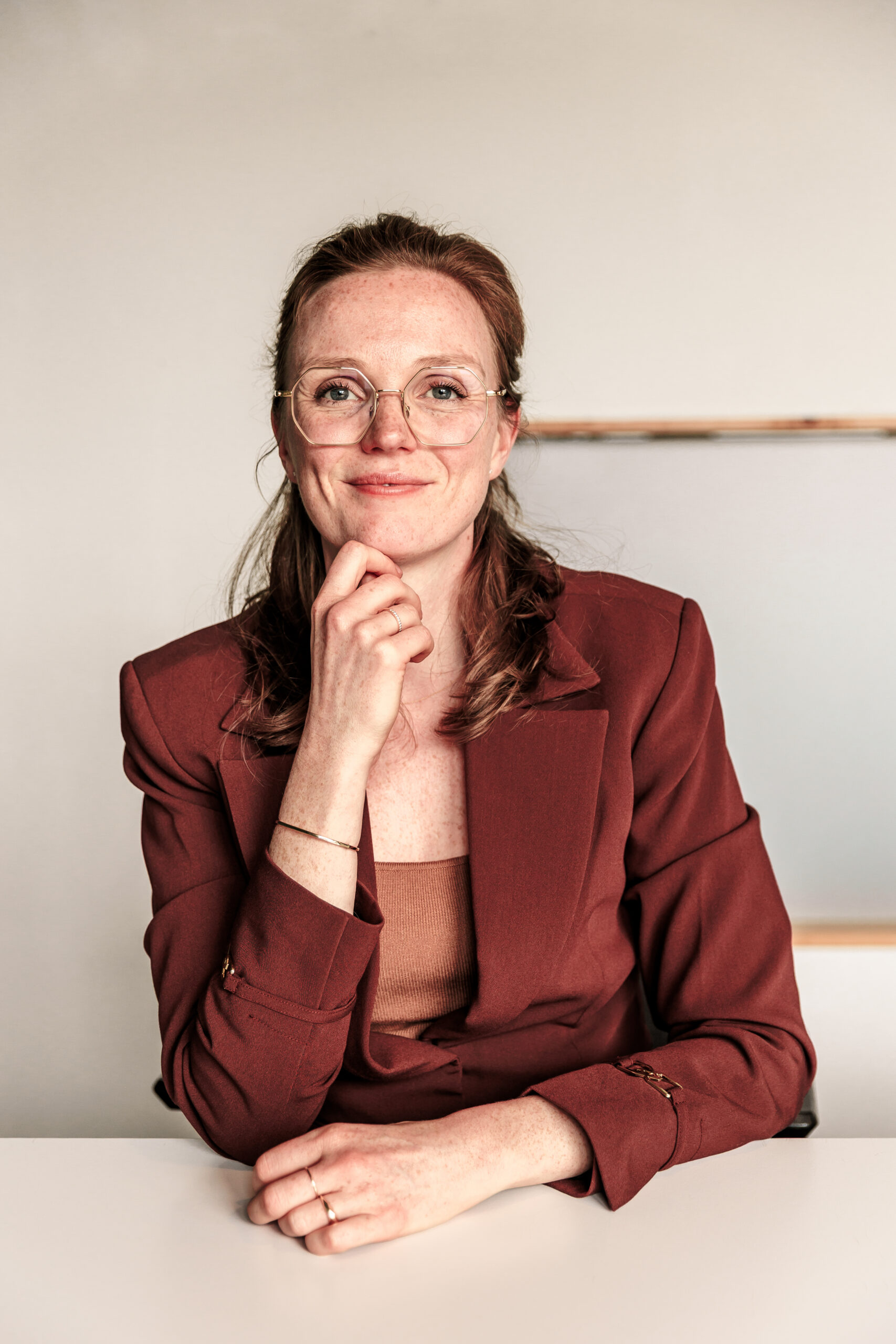 Foto van Monique, zittend aan een bureau
